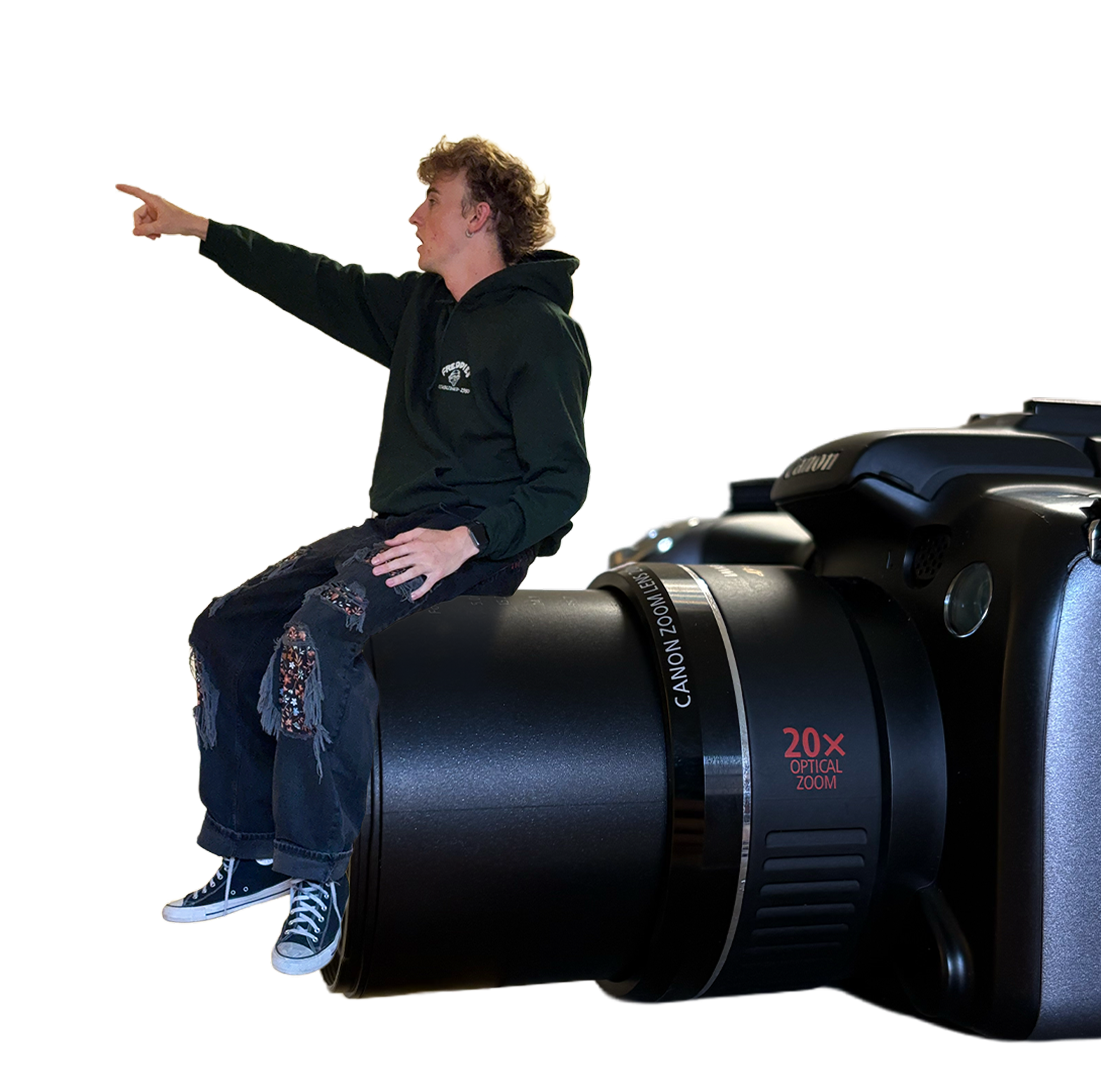 Kai sitting on a Canon camera, pointing at the lens