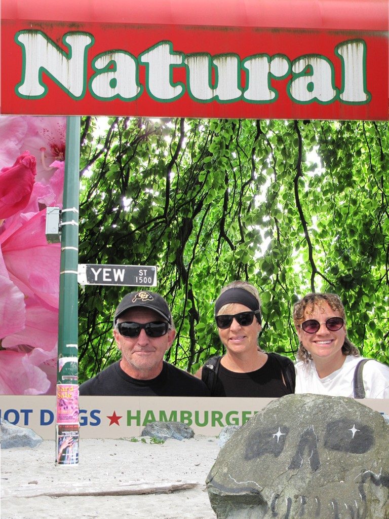Three people framed by Natural sign and street elements