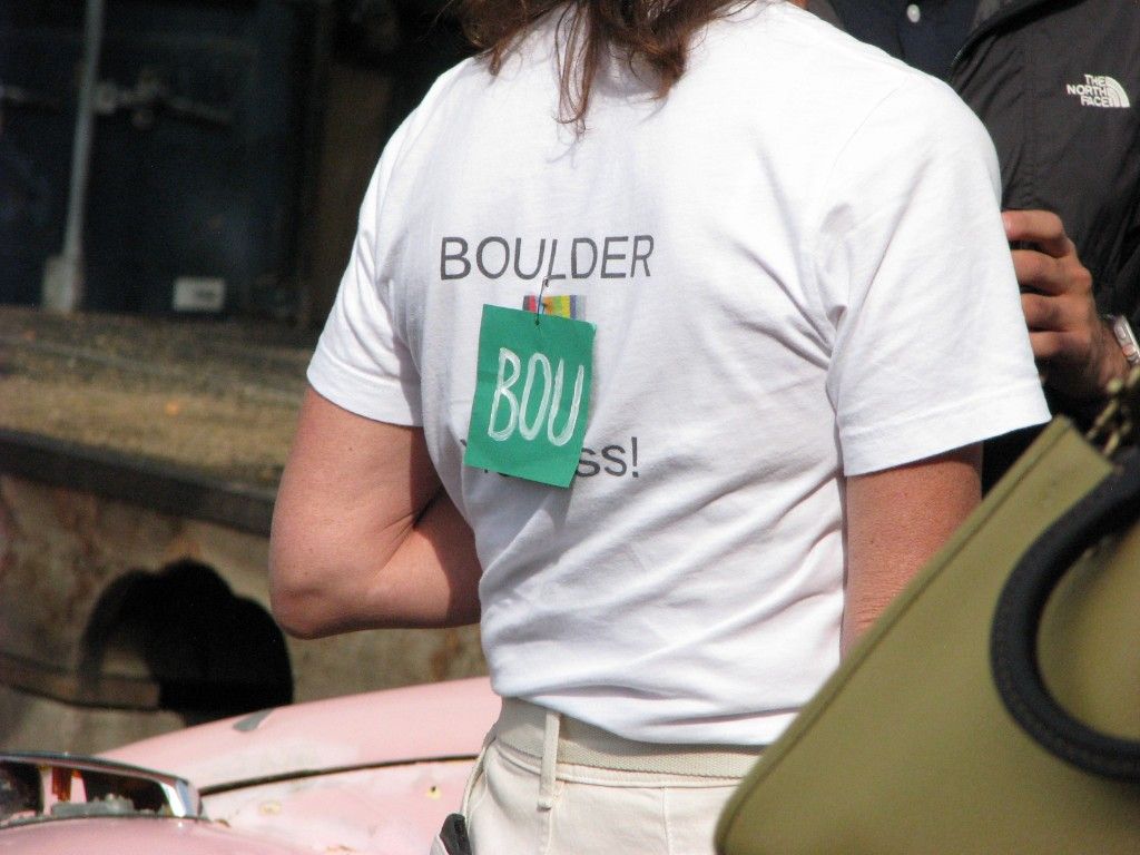 Back of a white Boulder shirt with a green BOU tag pinned on