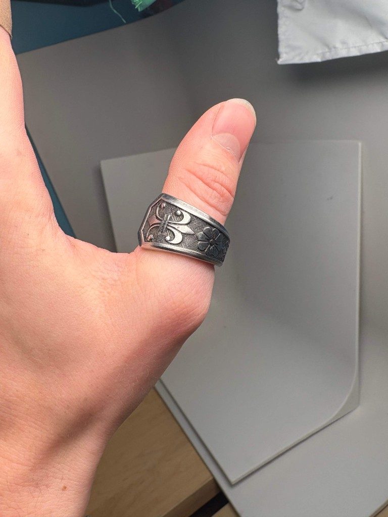 Floral fleur-de-lis silver spoon ring on thumb