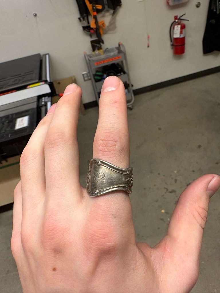 Silver spoon ring with engraved letter B on middle finger