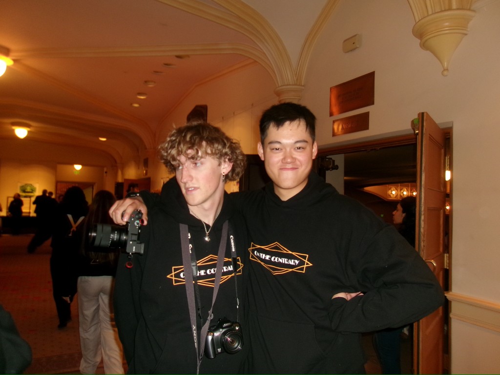 Two photographers in On the Contrary hoodies at a TEDx CU event