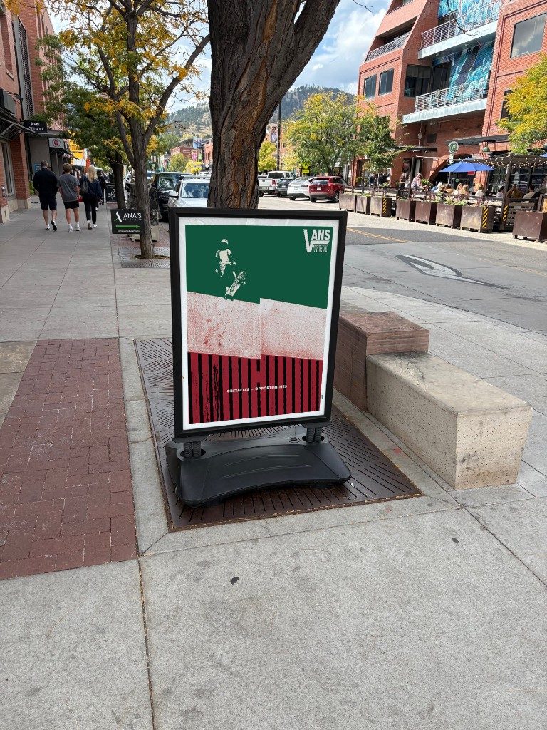 Pearl Street Vans sidewalk sign in downtown setting