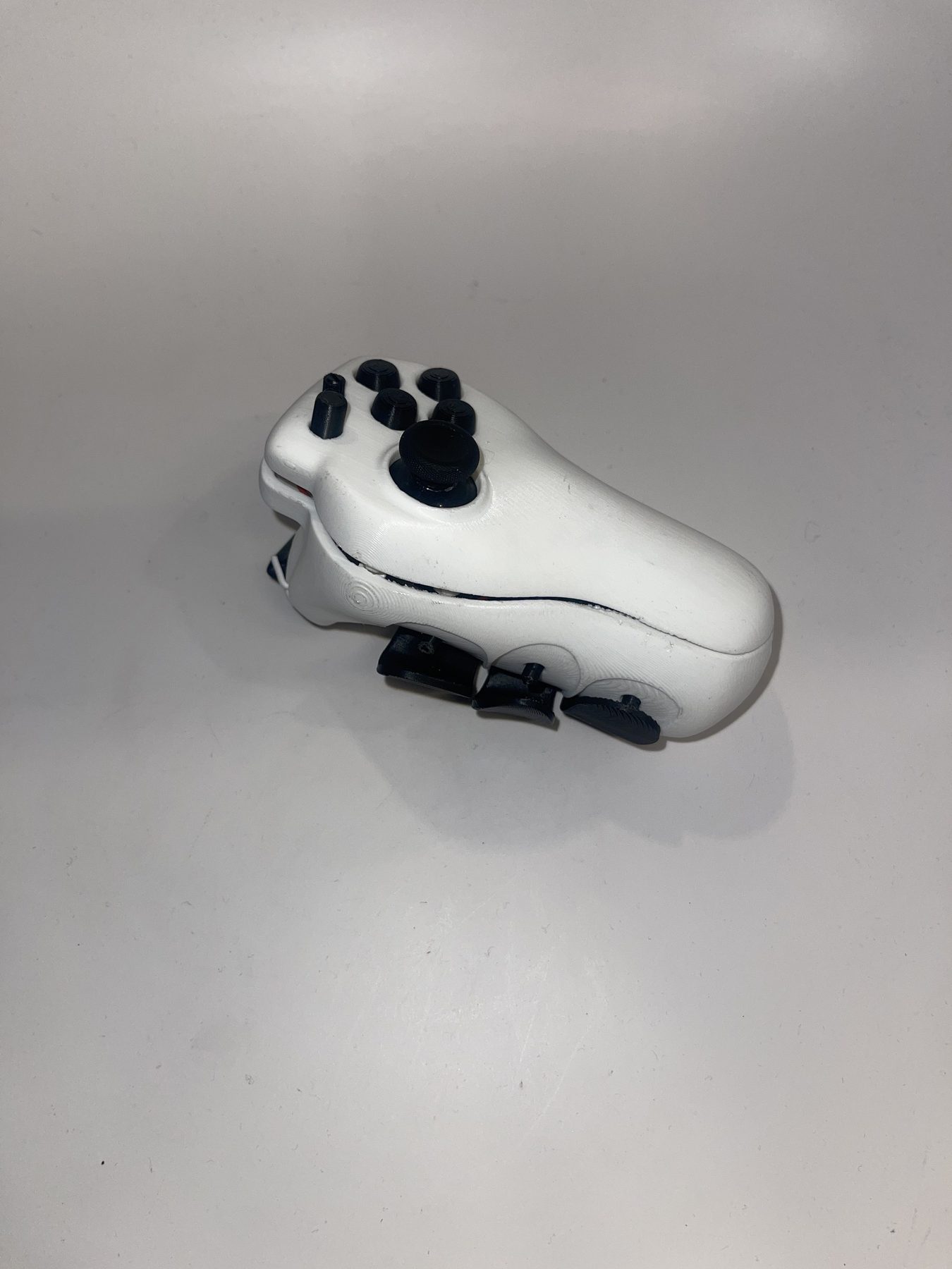 Assembled white SPUD one-handed controller with black buttons and joystick